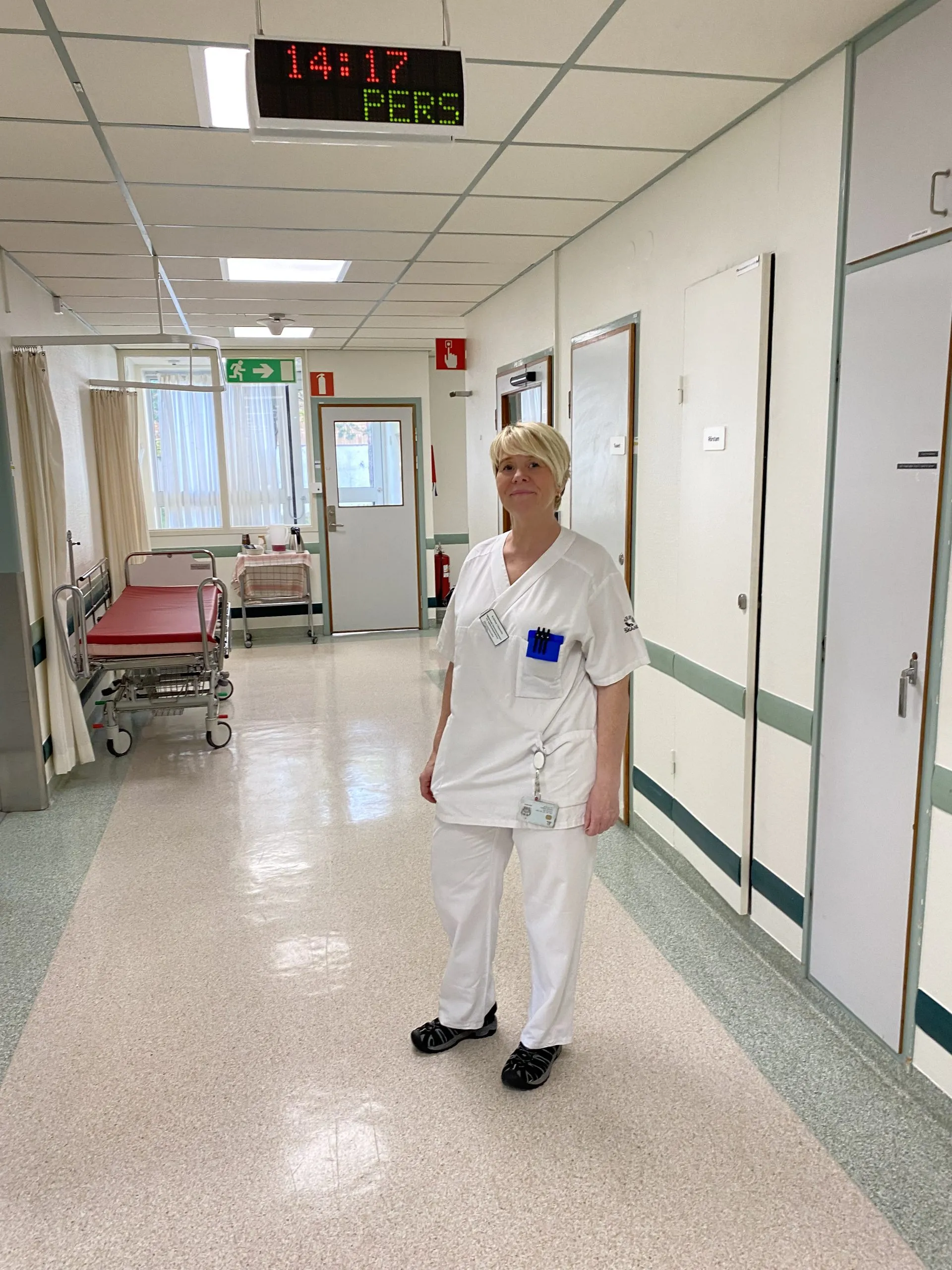 Person i vit rock som går i en sjukhuskorridor