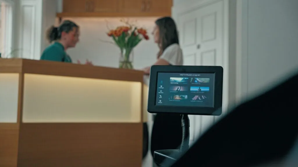 Personal vid en reception med en skärm i förgrunden
