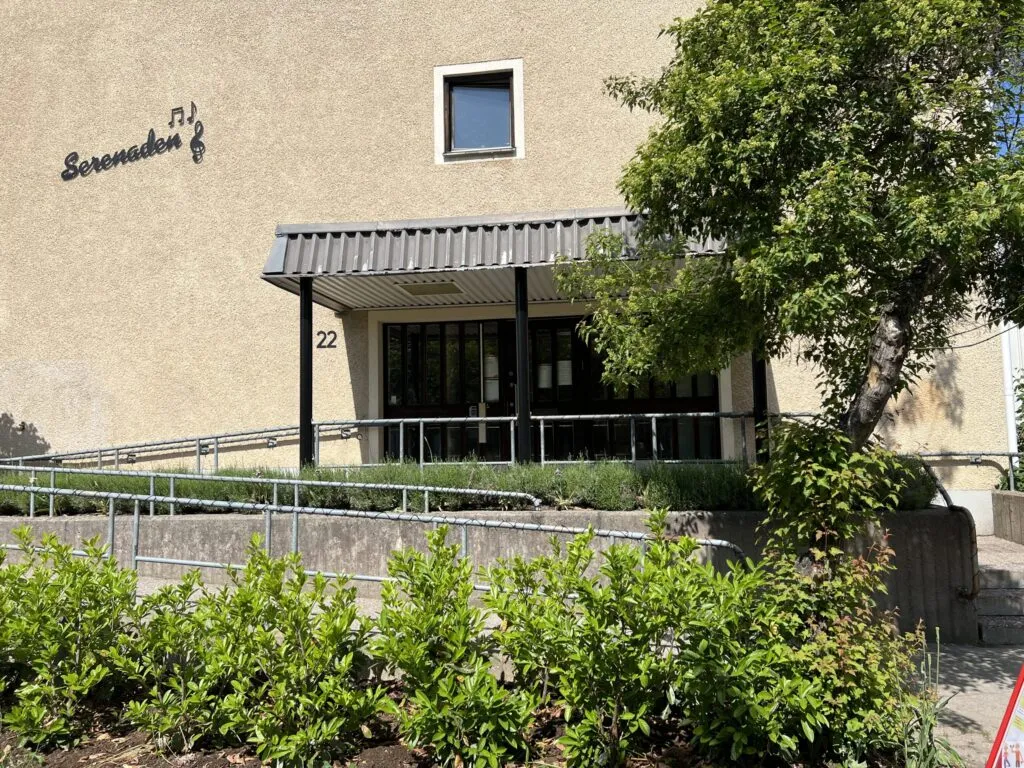 Husfasad med entré och grönska