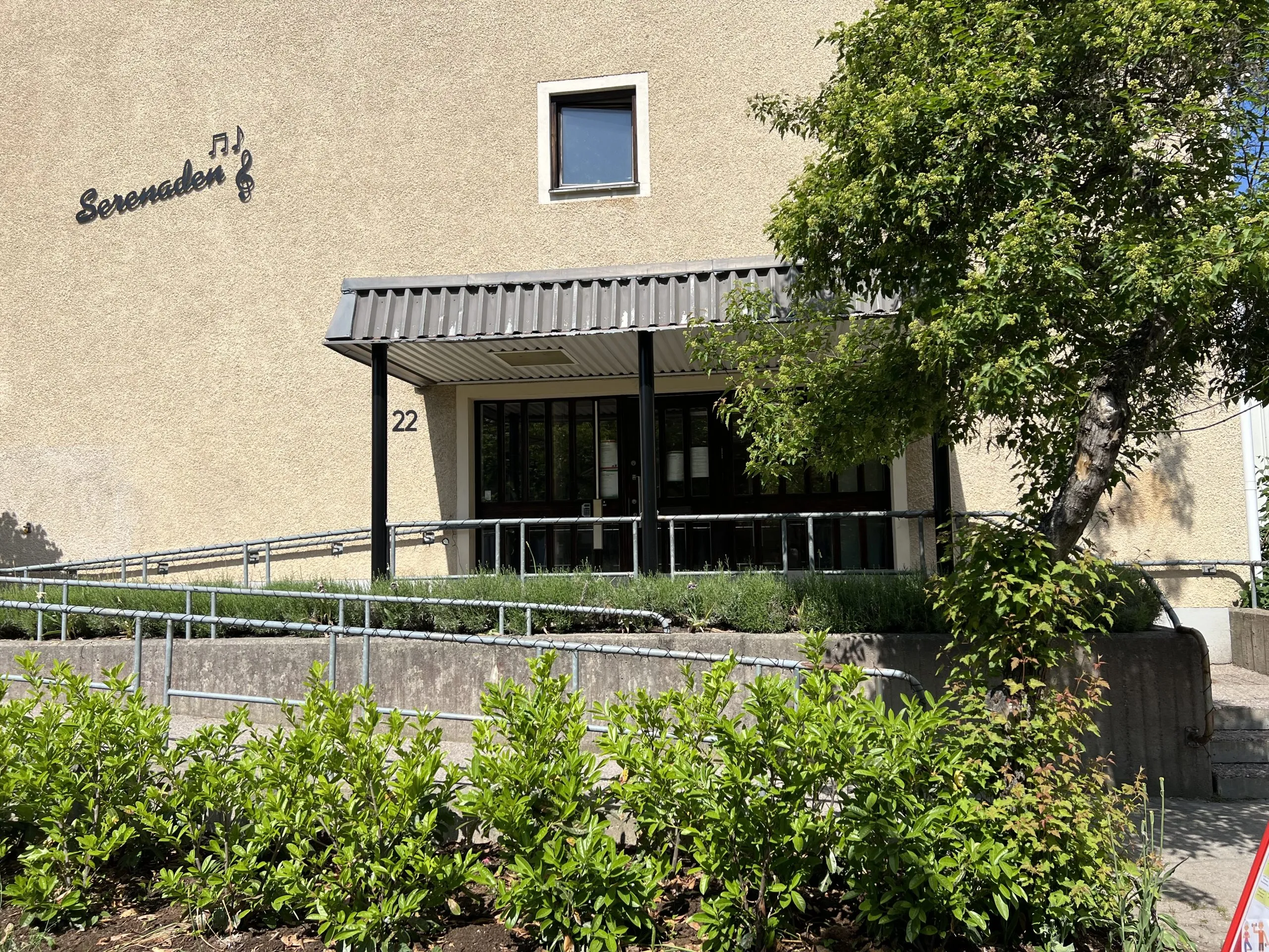 Husfasad med entré och grönska
