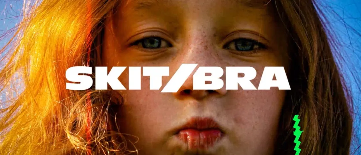 Närbild på ett ungt ansikte med Skit/Bras logotyp